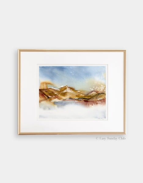 Gold framed mock up of rich earth-tone washes of color reveal a desert hill watercolor landscape