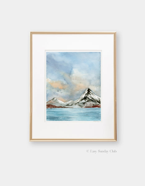 Gold framed mock up of cold, bright lake with snowy mountain and cumulus clouds in watercolor