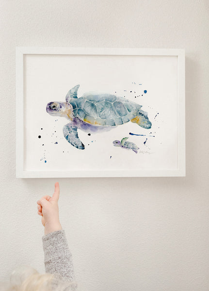 watercolor sea turtles art print showing one mother sea turtle swimming along with her baby sea turtle, framed in modern white frame.